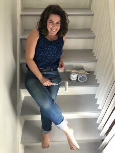  woman-sitting-on-stairs-with-paint-and-brush