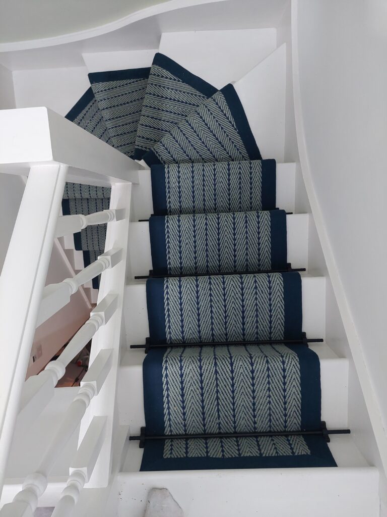 Herringbone-navy-on-pale-blue-stairrunner-fitted-to-winding-stairs